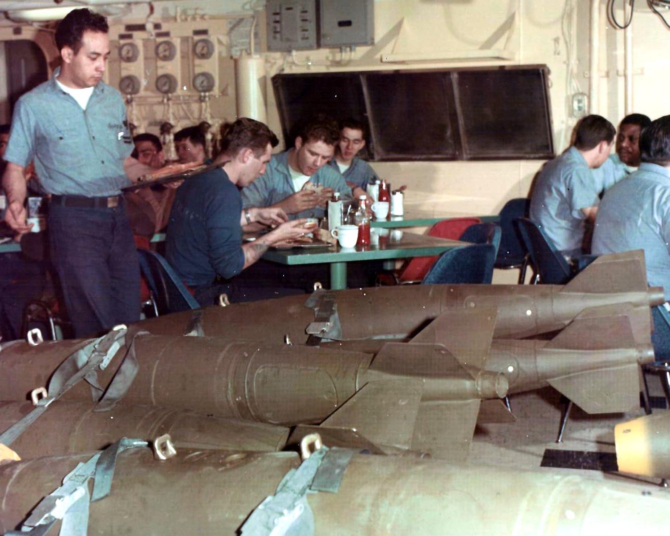 uss enterprise sailors eating lunch next to bombs